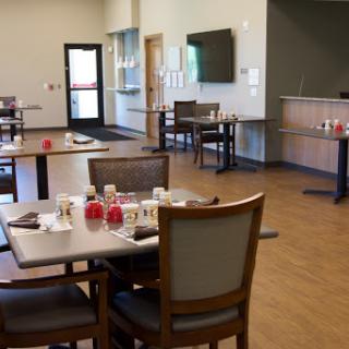 A spacious and modern dining area with neatly arranged tables and chairs, ready for guests.