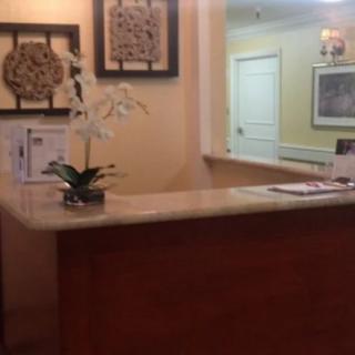 A welcoming reception desk with an orchid and wall decorations.