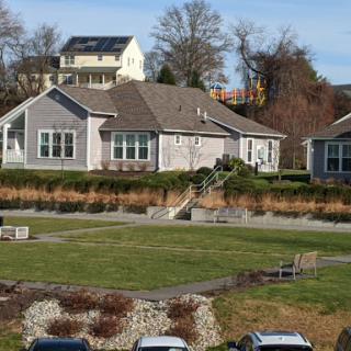 A picturesque residential house surrounded by well-maintained landscaping and open green space.