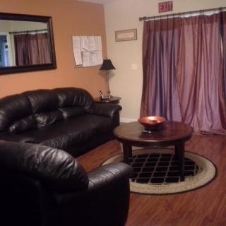 A cozy living room with leather seating and a round coffee table.