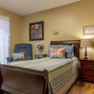 A cozy and well-decorated bedroom featuring a comfortable bed, decorative pillows, and warm lighting.