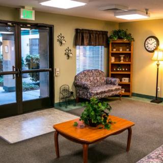 A cozy lobby area featuring a sofa, coffee table with plants, and decorative elements.