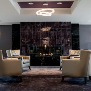 A modern seating area featuring armchairs and a stylish fireplace.