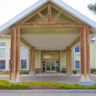 A building entrance with large wooden columns and a covered entryway.