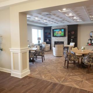 A spacious living room with a modern seating area and a large TV on the wall.