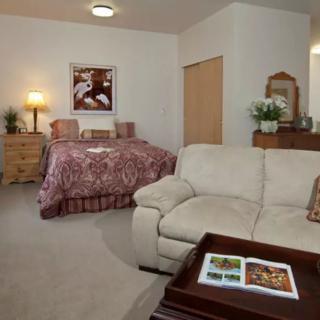 A cozy bedroom with a bed, sofa, and decor.