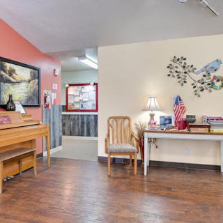 A cozy and inviting living area featuring a wooden floor, artistic touches, and comfortable furniture.