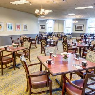 An empty dining room with neatly arranged tables and chairs.