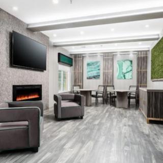 A modern lobby with comfortable seating, a fireplace, and contemporary artwork.