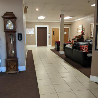 A spacious lobby area with a grandfather clock and seating arrangement.
