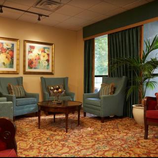 A cozy living room with comfortable seating, elegant decor, and vibrant artwork.