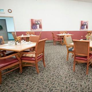 An empty restaurant dining area with neatly arranged tables and chairs.