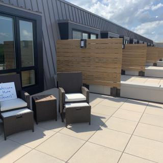 A modern rooftop patio with outdoor furniture and a clear sky.