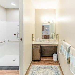 A clean, minimalist bathroom with a vanity area and walk-in shower.