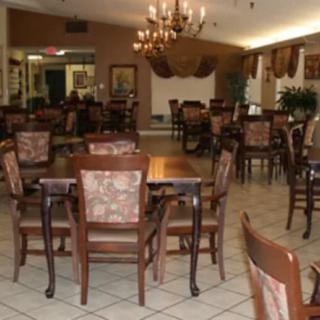 An elegant dining area with multiple tables and chairs under a beautiful chandelier.
