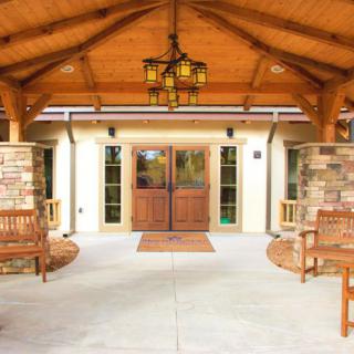 A welcoming building entrance with wooden accents and seating.