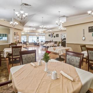 An elegant dining area with neatly arranged tables and chandeliers.