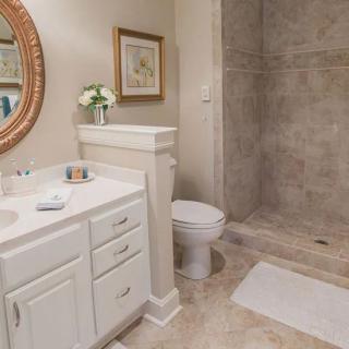 A modern bathroom featuring a sink, toilet, and spacious shower area.