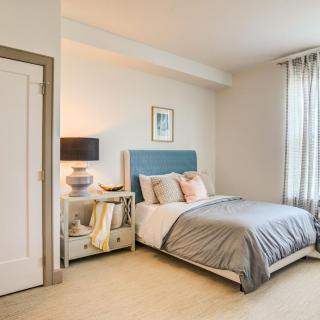 A modern and cozy bedroom with a blue headboard, soft bedding, and a stylish nightstand.
