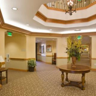 A well-lit lobby area with a round table and floral arrangement.