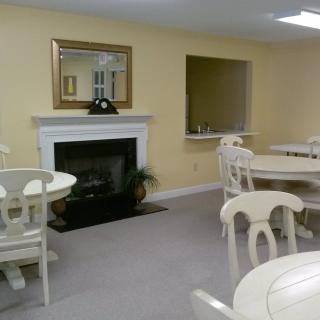 A cozy dining area featuring a fireplace, tables, and chairs in a warmly decorated room.
