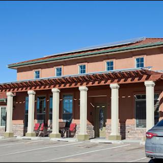 A beautifully designed commercial building featuring classic columns and a sunny exterior.