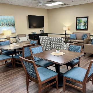A cozy and inviting lounge area featuring comfortable seating, dining tables, and a warm ambiance.