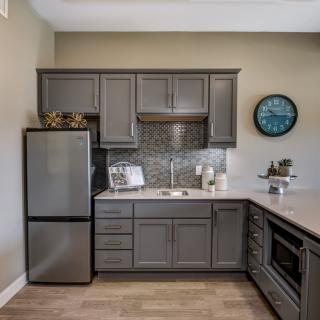 A modern kitchen with sleek gray cabinets and stainless steel appliances.