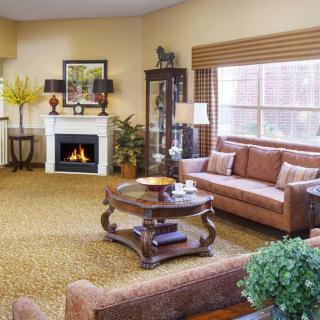 A cozy living room with a fireplace, comfortable seating, and elegant decor.