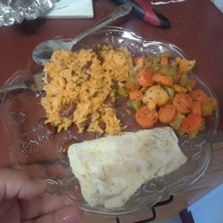 A colorful plate featuring seasoned rice, sauted vegetables, and a soft tortilla.
