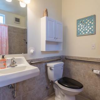A clean and simple bathroom with a sink, toilet, and wall-mounted storage.