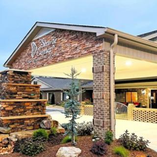 The entrance of a well-designed building with landscaped surroundings and a stone structure.