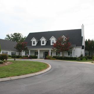A large suburban house with a neatly landscaped driveway.