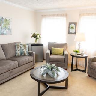 A cozy living room with a sofa, armchair, coffee table, and tasteful decor.