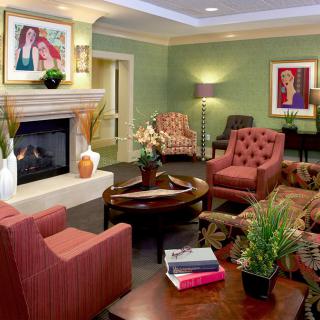 A cozy and stylish living room featuring comfortable seating, a fireplace, and decorative artwork.
