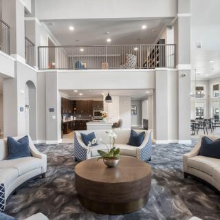 A spacious and elegantly designed living room with a contemporary open floor plan, featuring modern furniture and abundant natural light.