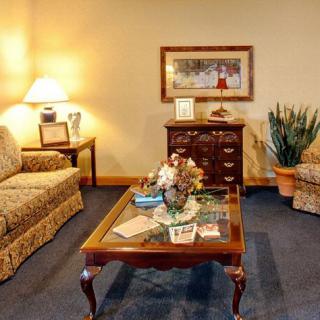 A cozy living room with a patterned sofa, a wooden coffee table, a floor lamp, and decorative items.