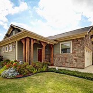 A beautiful house with a stone facade and well-maintained landscaping.