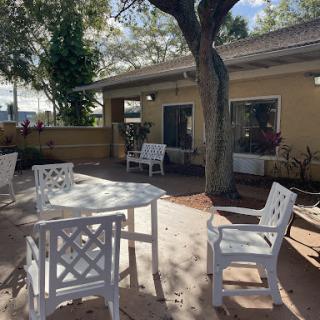 A serene outdoor patio area with white furniture and natural surroundings.