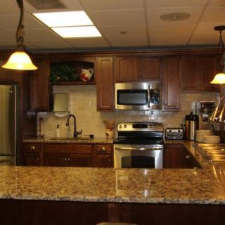 A modern kitchen with granite countertops and wooden cabinets.