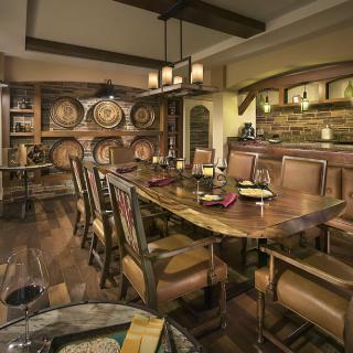A rustic dining room featuring wooden furniture and wine barrels, creating a cozy and inviting atmosphere.