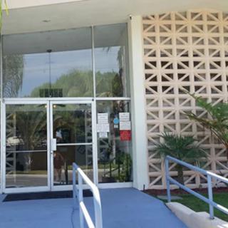 A modern building entrance featuring glass doors and an accessibility ramp.