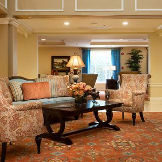 A cozy living room with elegant furnishings including a sofa, armchairs, and a decorative coffee table.