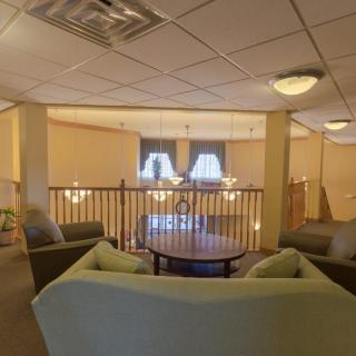 A cozy lounge area with sofas, a round table, and elegant lighting.