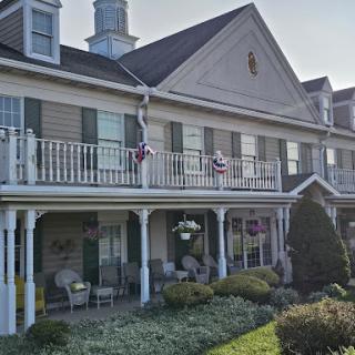 A charming residential building with porches and well-maintained landscaping.