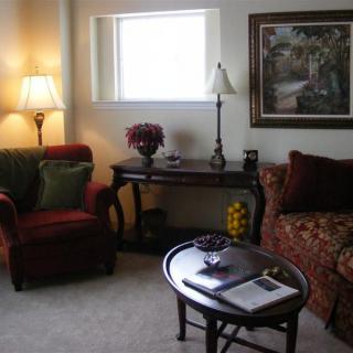 A cozy living room with a sofa, armchair, and warm lighting.