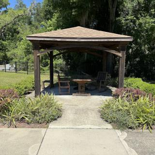 A serene gazebo surrounded by lush greenery, perfect for relaxation.
