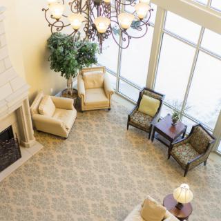 A cozy living room with a fireplace, elegant chandelier, and comfortable seating area.