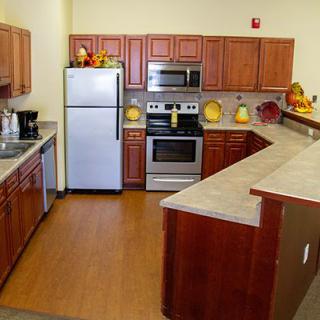 A modern kitchen with wood cabinets and stainless steel appliances.