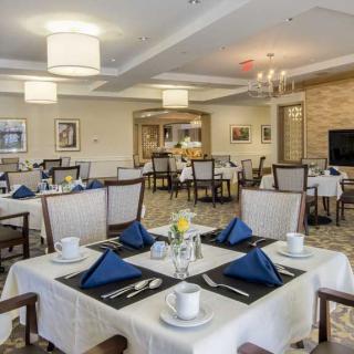 An elegantly set dining area with neatly arranged tables and chairs, showcasing a sophisticated interior design.
